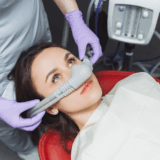 Patient receiving dental sedation while reclining in a treatment chair